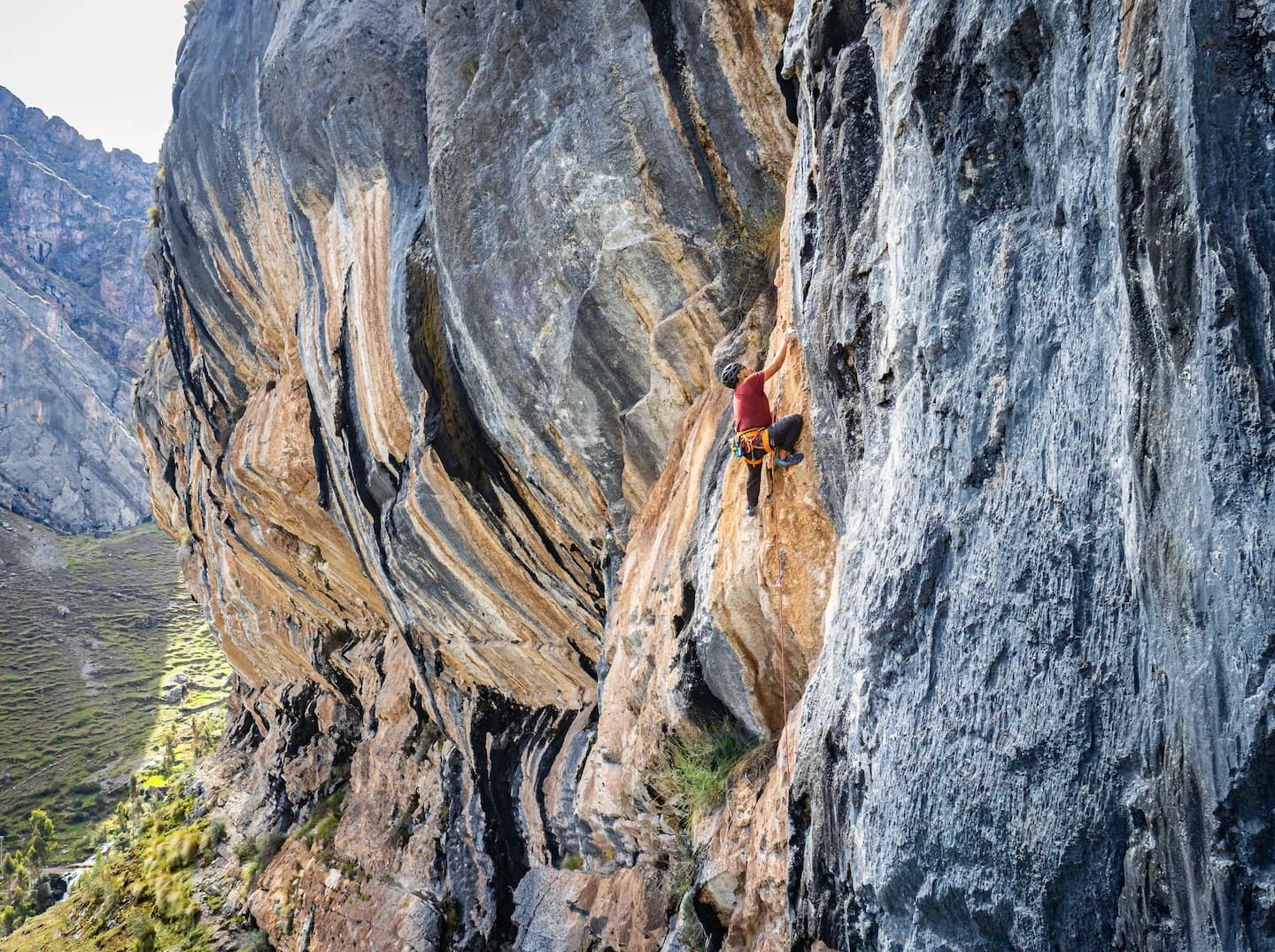 Climber on a limestone wall above an Andean valley in Peru.