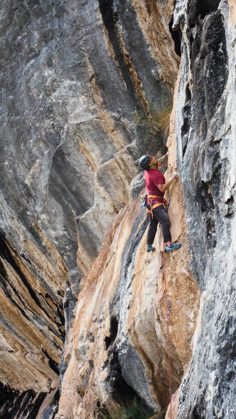 Climber on textured cliff face.