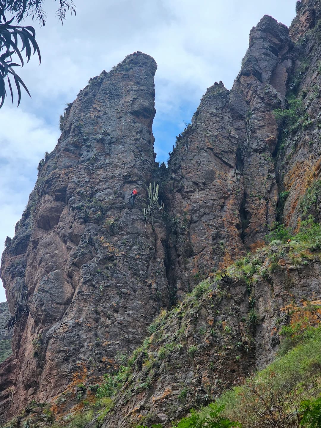 High valley limestone walls in Peru with a climber on the rock.